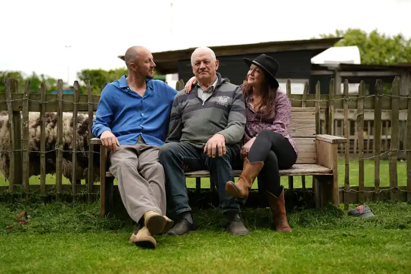 Willem, Wim en Hanne samen op de bank bij de boerderij
