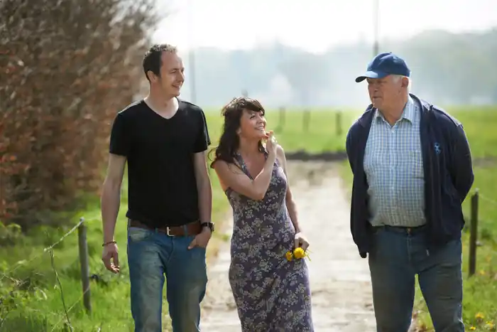 Drie familieleden wandelend over een landweg bij de boerderij