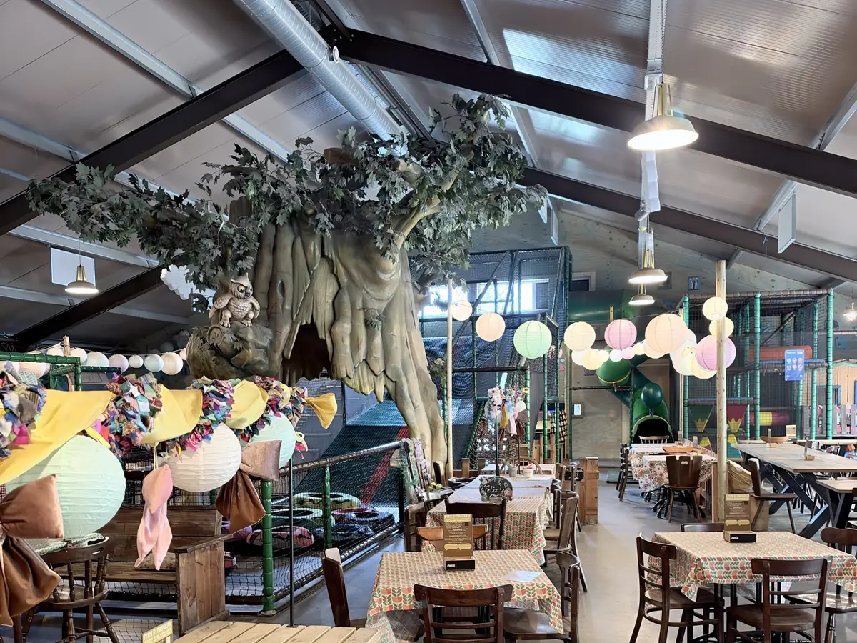 De grote binnenhal met de klimboom en de tafels