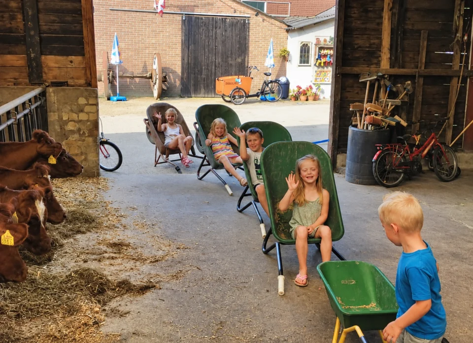 kinderen in de klafjestal met hun kruiwagens