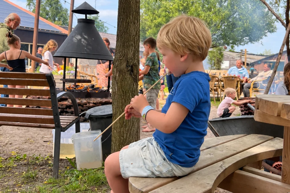 kind dat marshmallow eet bij het kampvuur
