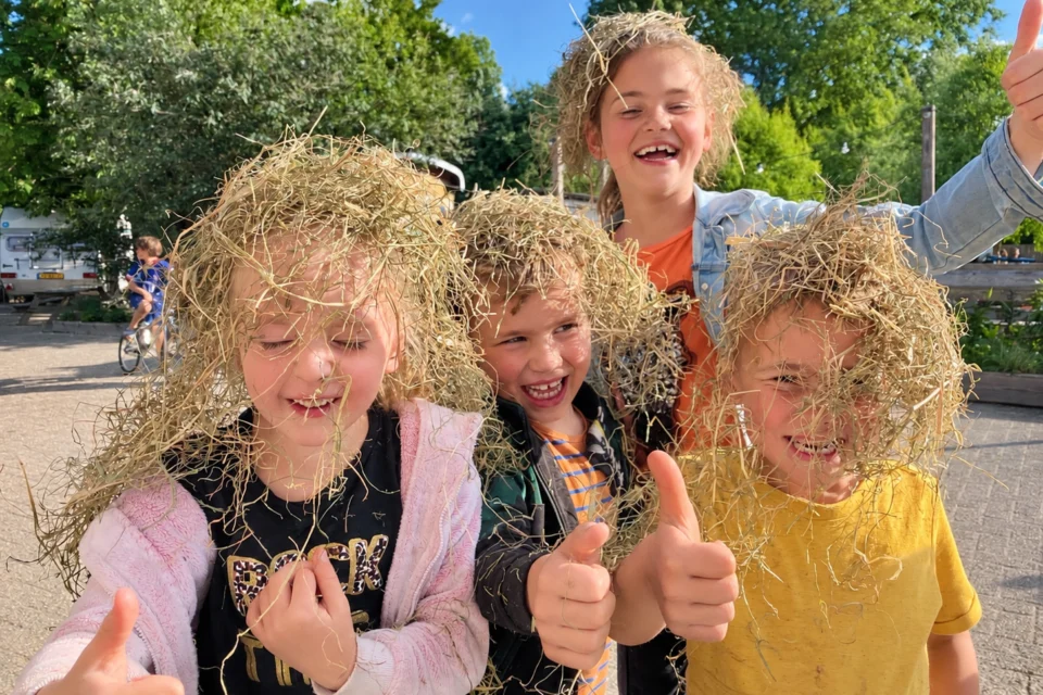 kinderen met hooi op hun hoofd